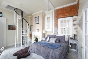 River suite with spiral staircase to the left in the background, blue bedding.