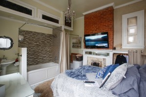 Bourbon room with light blu bedding and shower tub and sick in the background.