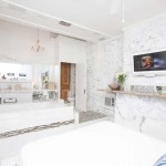 Jacuzzi tub, foot of bed, mantle with TV hanging above it.