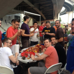 The gathered around the table enjoy eating boiled crawfish.